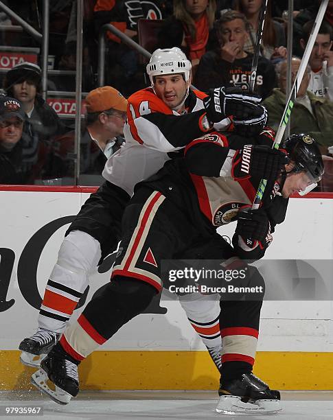 Brent Sopel of the Chicago Blackhawks is hit by Ian Laperriere of the Philadelphia Flyers at the Wachovia Center on March 13, 2010 in Philadelphia,...