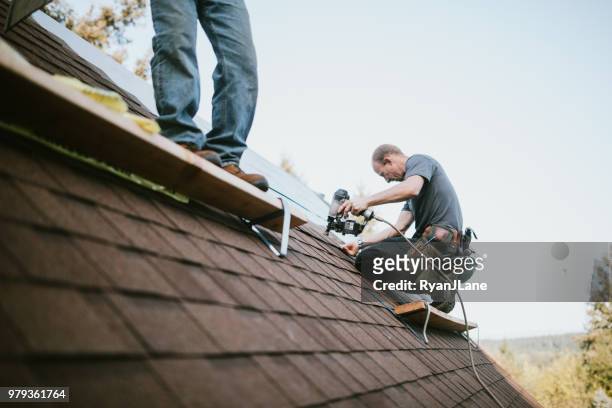 general contractor installing new roof - manutenção imagens e fotografias de stock