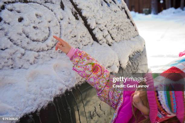 girl making a happy face shape on a car with snow - freeze ideas stock pictures, royalty-free photos & images