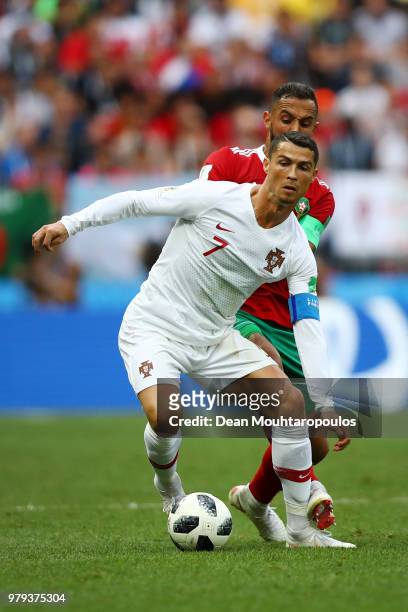 Cristiano Ronaldo of Portugal is challenged by Mehdi Benatia of Morocco during the 2018 FIFA World Cup Russia group B match between Portugal and...