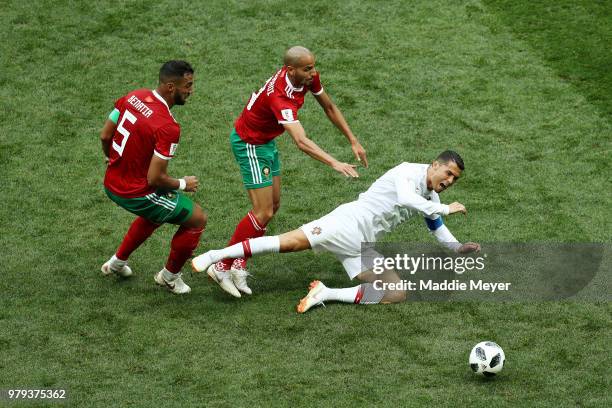 Cristiano Ronaldo of Portugal is tackled by Mehdi Benatia and Karim El Ahmadi of Morocco during the 2018 FIFA World Cup Russia group B match between...