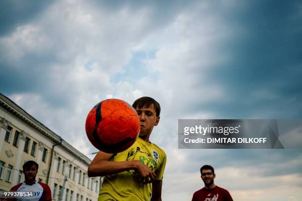 Picture taken on June 19 shows Russian youths playing football in the Fan Zone in the city of Nizhny Novgorod, during of the Russia 2018 World Cup...