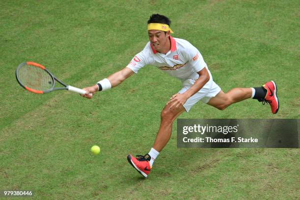 Kei Nishikori of Japan plays a forehand in his match against Karen Khachanov of Russia during day three of the Gerry Weber Open at Gerry Weber...