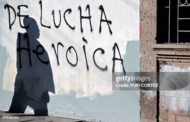 Man casts his shadow over a grafitti against the coup after polling stations were closed during general elections in Tegucigalpa, on November 29,...