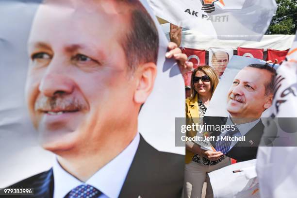 Woman holds an election poster showing the portrait of Turkey's President Recep Tayyip Erdogan on June 20, 2018 in Istanbul, Turkey. Presidential...