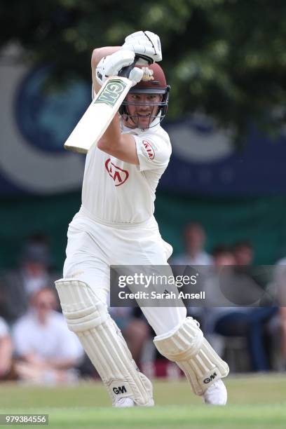 Rory Burns of Surrey hits a boundary to bring up a half century during day 1 of the Specsavers County Championship Division One match between Surrey...