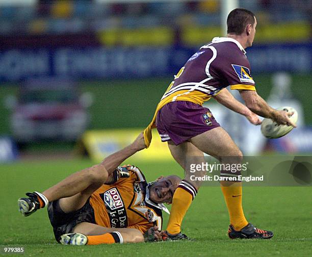 Tyran Smith of Wests Tigers tries to hang onto Ben Ikin of Brisbane during the NRL round four match between the Brisbane Broncos and Wests Tigers...