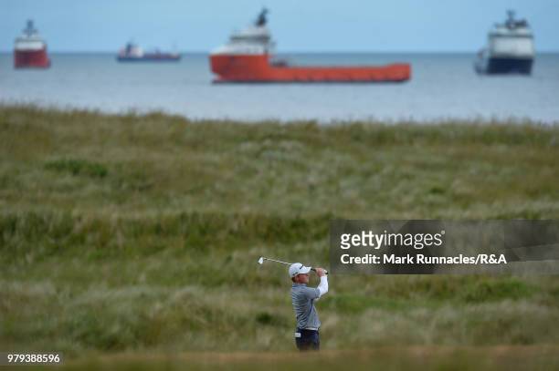 Angus Flanagan of St Georges Hill plays his second shot to the 13th hole during the third day of The Amateur Championship at Royal Aberdeen on June...