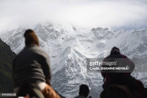 In this photograph taken on June 19 Indian Hindu devotees make their way to pay respects at the restored Kedarnath Temple that was hit during the...