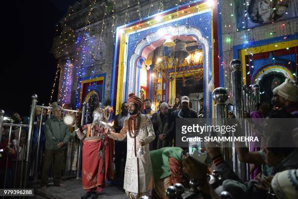 In this photograph taken on June 18 Indian Hindu priests perform Arti prayers at the restored Kedarnath Temple that was hit during the deadly 2013...