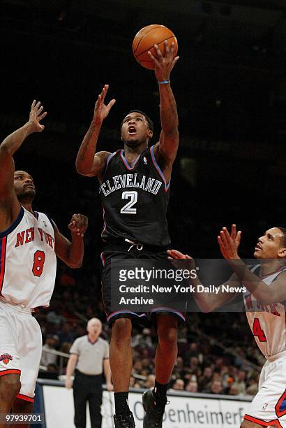 Cleveland Cavaliers' Dajuan Wagner takes a shot while guarded by New York Knicks' Latrell Sprewell and Howard Eisley. The Knicks trounced the Cavs,...