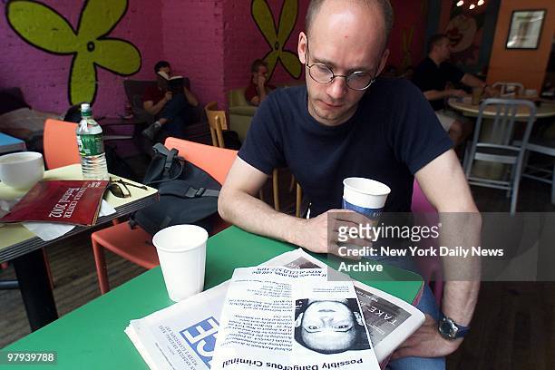 Chris Denning of London sits in Chelsea coffee shop as he looks at a flyer announcing search for British murder suspect Richard Markham. Markham was...