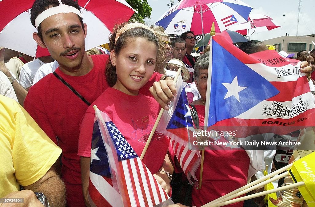 Youngster carries American and Puerto Rican flags at a cerem