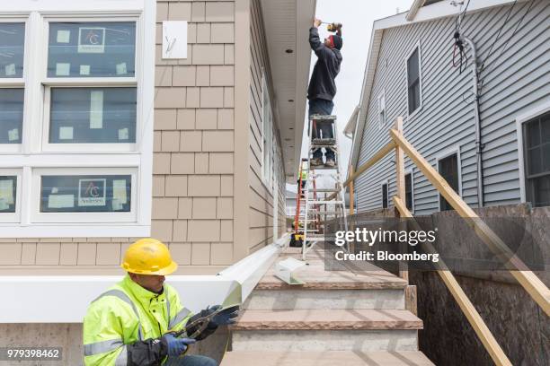 Workers install a gutter during construction of a home designed to withstand extreme weather in the Breezy Point neighborhood of the Queens borough...
