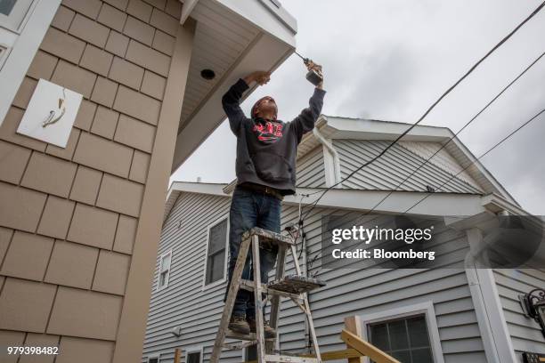 Worker installs a gutter during construction of a home designed to withstand extreme weather in the Breezy Point neighborhood of the Queens borough...