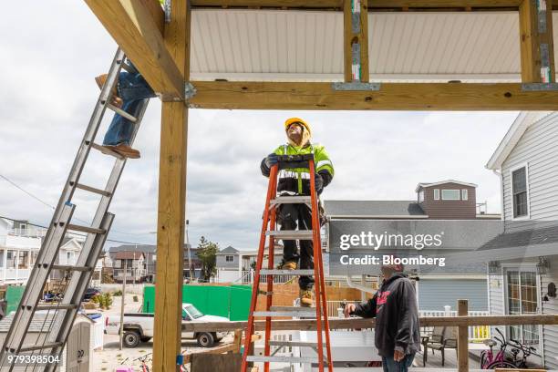 Workers install a gutter during construction of a home designed to withstand extreme weather in the Breezy Point neighborhood of the Queens borough...