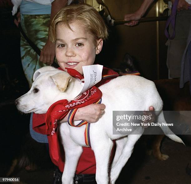 Young actor Josh Ryan Evans hoists a pooch which is up for adoption during the Broadway Barks 3! benefit at Shubert Alley. The annual event...