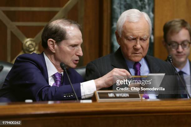 Senate Finance Committee Chairman Orrin Hatch and ranking member Sen. Ron Wyden talk while hearing testimony from U.S. Secretary of Commerce Wilbur...