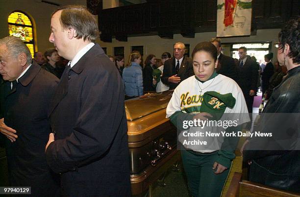 Young mourner wears her Bishop Kearney High School junior varsity softball team jersey as she stands by the coffin of her coach, Franco Pomponio,...