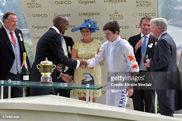 Sir Mo Farah presents The Queen Mary Stakes trophy to winning jockey Oisin Murphy on day 2 of Royal Ascot at Ascot Racecourse on June 20, 2018 in...