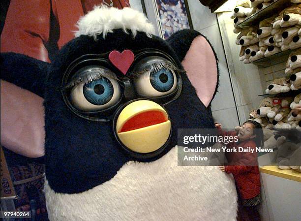 Youngster gets close to a giant Furby on display in FAO Schwarz toy store. In the smaller version, Furbys have become the hottest toys of the holiday...