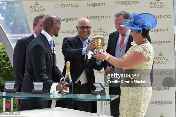 Sir Mo Farah presents the winners cup to winning breeder Dermot Farrington from Diomed Bloodstock Ltd after their horse Signora Cabello won the The...