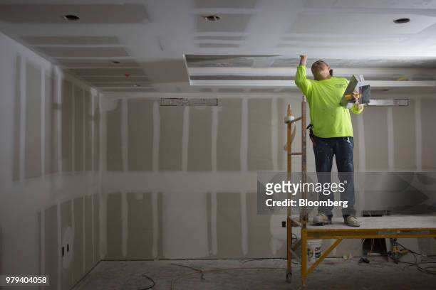 Worker spackles the ceiling of a flood proof room during construction of the 121 Marina residential condominium complex designed to withstand extreme...