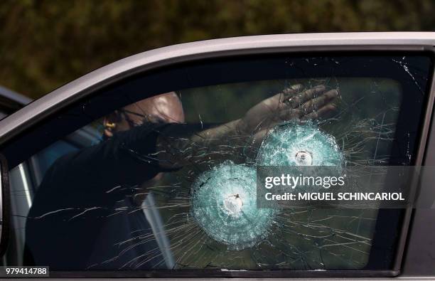 Technician points at the shot of a .357 Magnum at the window of an armoured car, at a company in Maua, Sao Paulo, Brazil on December 15, 2017. - The...