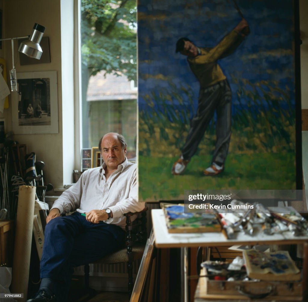 Portrait of British artist Harold Riley with a painting of a golfer ...