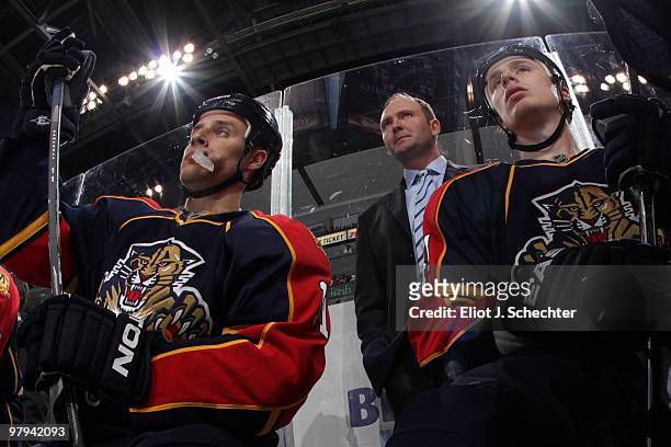 Head Coach Peter DeBoer of the Florida Panthers watches the action with team members Gregory Campbell and Shawn Matthias from the bench against the...