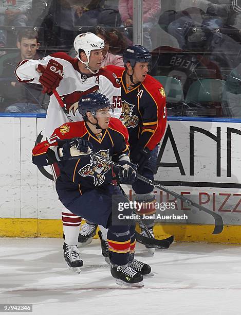 Stephen Weiss and David Booth of the Florida Panthers look towards the corner with Ed Jovanovski of the Phoenix Coyotes on March 18, 2010 at the...