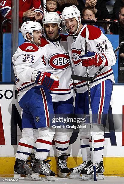 Brian Gionta, Scott Gomez and Benoit Pouliot of the Montreal Canadiens celebrate a first period goal against the Toronto Maple Leafs during the game...