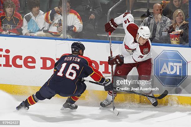Nathan Horton of the Florida Panthers and Taylor Pyatt of the Phoenix Coyotes battle along the boards on March 18, 2010 at the BankAtlantic Center in...