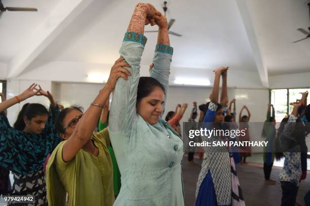 An Indian teacher guides a visually impaired girl participating on a yoga class at Andh Kanya Prakash Gruh in Ahmedabad on June 20 on the eve of...