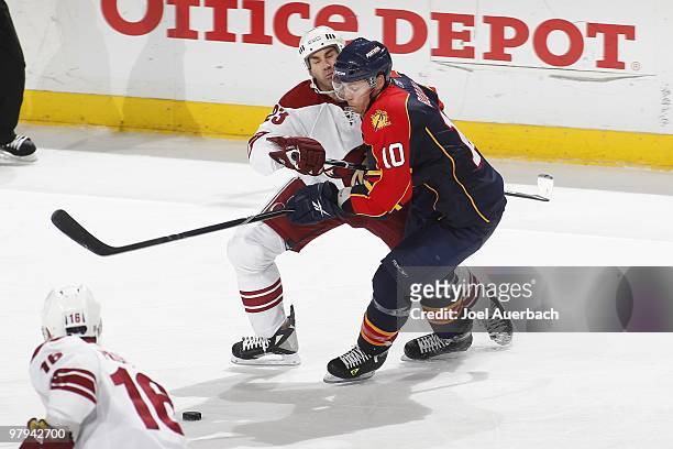 Mathieu Schneider of the Phoenix Coyotes and David Booth of the Florida Panthers skate after a loose puck on March 18, 2010 at the BankAtlantic...