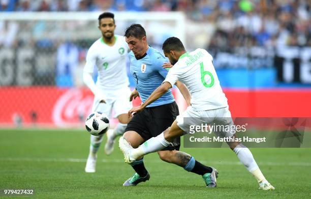 Cristian Rodriguez of Uruguay is tackled by Mohammed Alburayk of Saudi Arabia during the 2018 FIFA World Cup Russia group A match between Uruguay and...