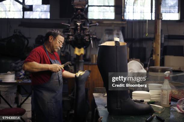 Leather boot form sits on a table as a worker attaches a shoe sole at the Dehner Co. Factory in Omaha, Nebraska, U.S., on Tuesday, June 5, 2018....