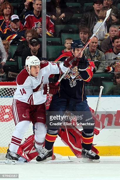 Bryan Allen of the Florida Panthers crosses sticks with Taylor Pyatt of the Phoenix Coyotes at the BankAtlantic Center on March 18, 2010 in Sunrise,...