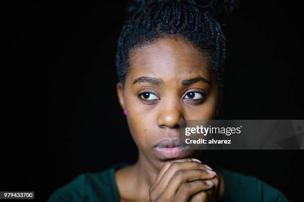 close-up of worried woman looking away - woman black background stock pictures, royalty-free photos & images