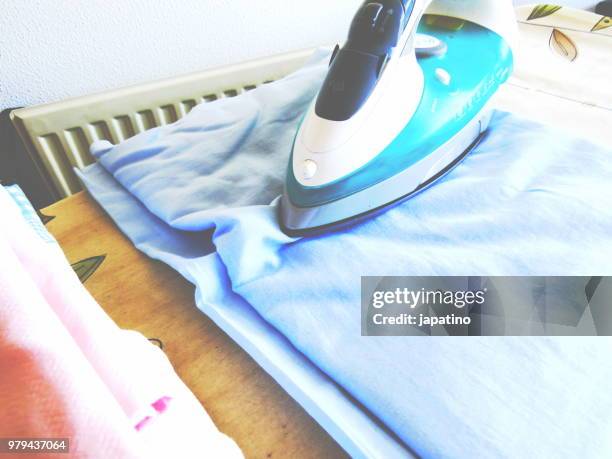 homework. ironing of clothes on ironing board - pantalón decorado fotografías e imágenes de stock