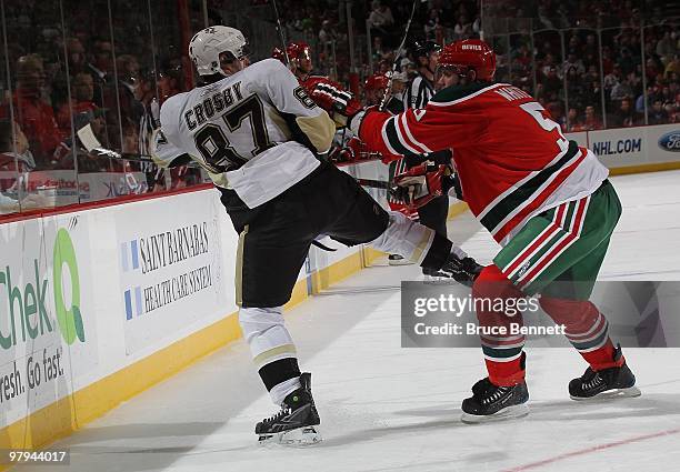 Sidney Crosby of the Pittsburgh Penguins is hit by Colin White of the New Jersey Devils at the Prudential Center on March 17, 2010 in Newark, New...