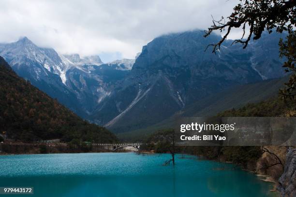 mountain range of yulong snow mountain over lake, lijiang, yunnan, china - lijiang bildbanksfoton och bilder
