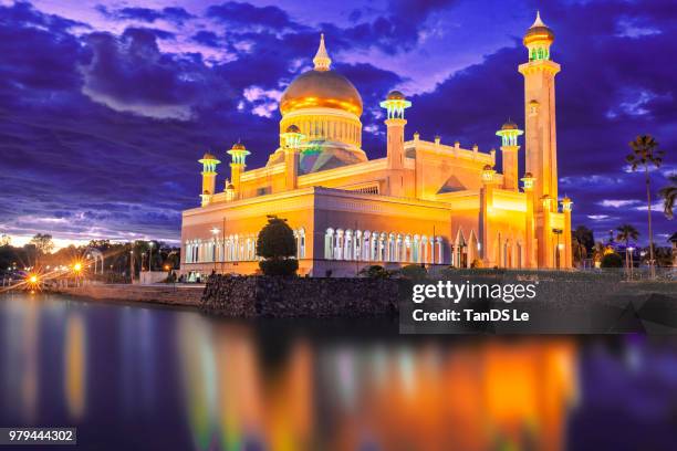 illuminated mosque by lake at night, brunei - bandar seri begawan foto e immagini stock