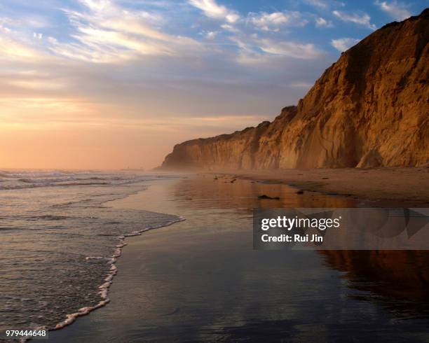 sunset over beach with rocky mountain, torrey pines state park, california, usa - la jolla imagens e fotografias de stock