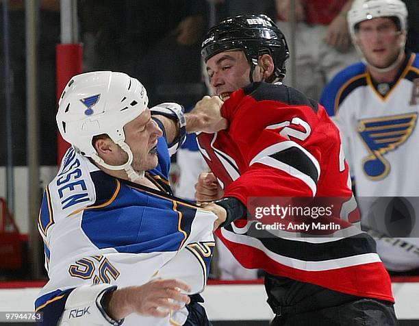 Cam Janssen of the St. Louis Blues and Pierre-Luc Letourneau-Leblond of the New Jersey Devils trade punches during a first period fight at the...