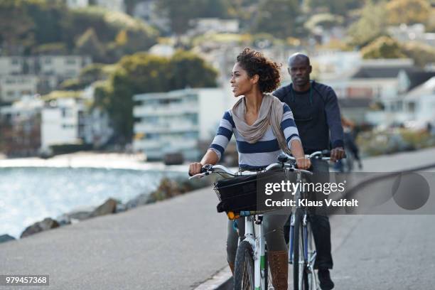 couple using rental bikes in the small town sausalito - san francisco bay area stockfoto's en -beelden