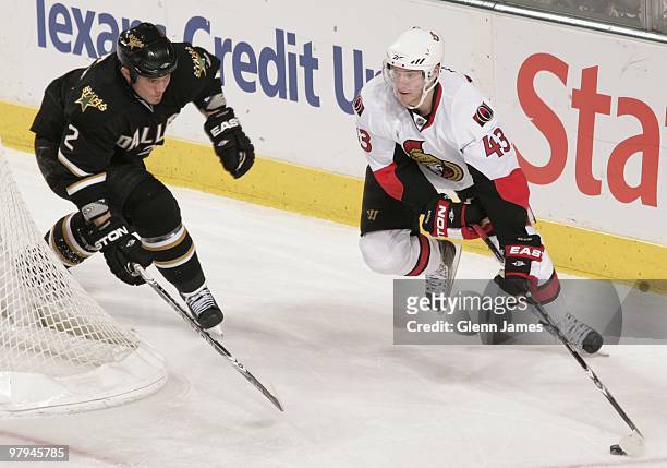 Peter Regin of the Ottawa Senators skates against Nicklas Grossman of the Dallas Stars on March 20, 2010 at the American Airlines Center in Dallas,...