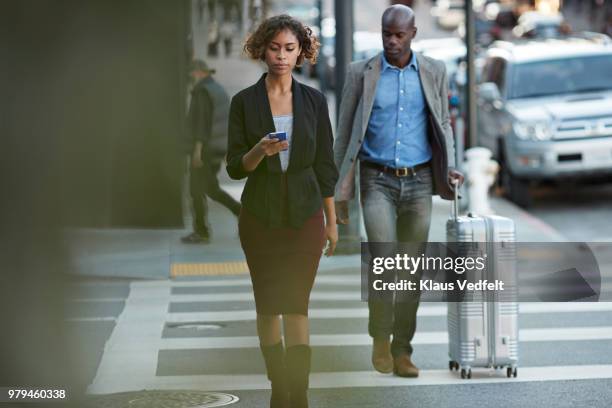 businesswoman checking smartphone while walking on pedestrian crossing - dark haired man gray shirt with wine stock pictures, royalty-free photos & images