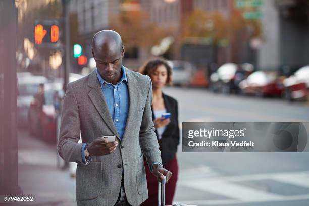 businesspeople walking in pedestrian crossing and checking smartphones - american red cross fotografías e imágenes de stock