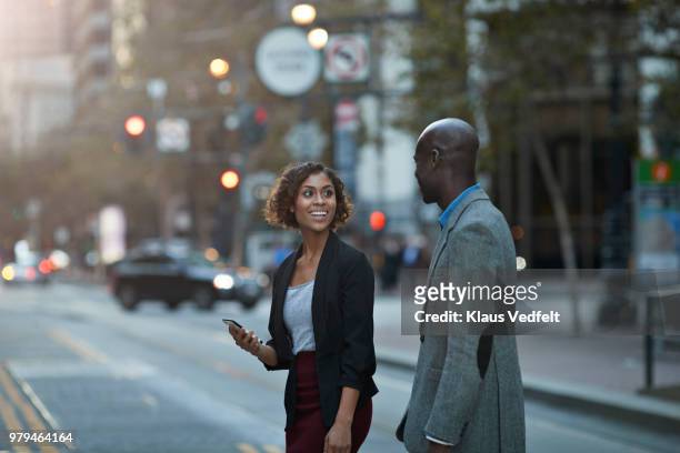 businesspeople walking and talking on avenue of san francisco - mann zwei telefone stock-fotos und bilder